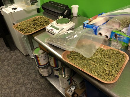 The inside of a kitchen segment in a bar with a messy counter surface