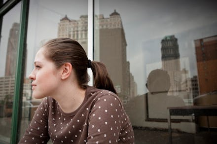 A young entrepreneur with her hair tied in a ponytail, sitting on a terrace in Detroit 