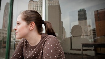 A young entrepreneur with her hair tied in a ponytail, sitting on a terrace in Detroit 