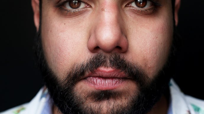 A close-up portrait of Heems, the most exciting new name in hip-hop in a white-and-blue shirt