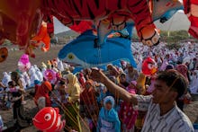 People celebrating Eid in a group while holding balloons