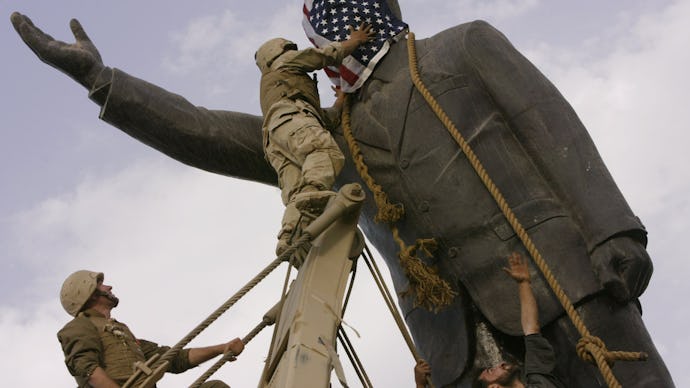Soldiers putting an American flag over the head of a statue in Iraq