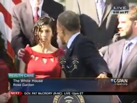 Woman in a red dress fainting during Obama's ACA speech