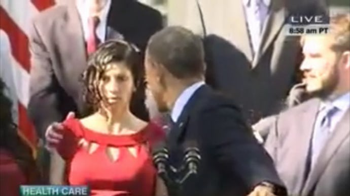 Woman in a red dress fainting during Obama's ACA speech