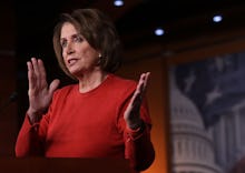 House Minority Leader Nancy Pelosi, wearing a red sweater while giving a speech