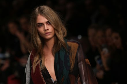 Cara Delevingne walking on a runway during a fashion show