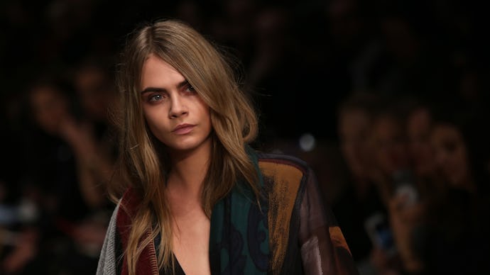 Cara Delevingne walking on a runway during a fashion show