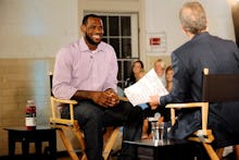 LeBron James in white and red stripped shirt sitting in a chair during his interview with Jim Gray