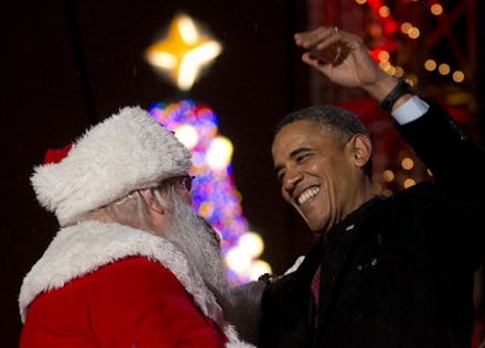 Barack Obama going in for a hug with a man dressed as Santa Claus