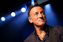 Bruce Springsteen on stage with spotlights behind him