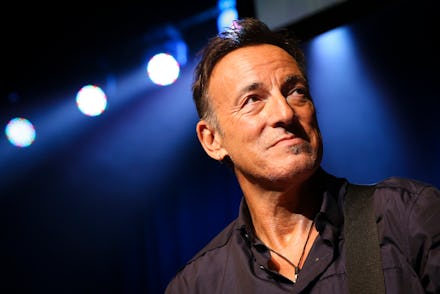 Bruce Springsteen on stage with spotlights behind him