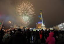 Ukraine's Maidan square filled with fireworks and groups of people