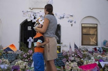 A mother hugging her son in front of the Charleston Church massacre memorial wall