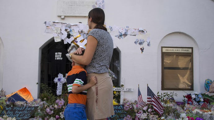 A mother hugging her son in front of the Charleston Church massacre memorial wall