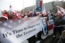 A group of protesters holding a large poster 'It's Time to Super-Size the Economy'