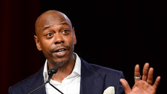 Dave Chappelle in a formal suit during a performance