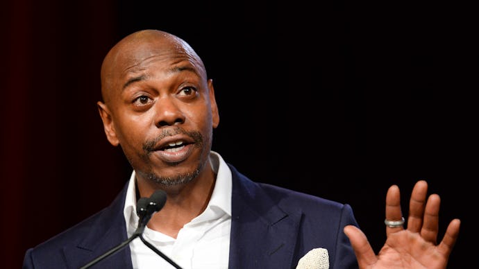 Dave Chappelle in a formal suit during a performance