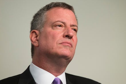 A close-up portrait of Bill de Blasio with a serious facial expression