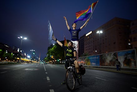 Two boys riding on a bicycle down a road