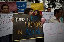 Pakistani people during the riots, holding "there is no honor in killing" signs