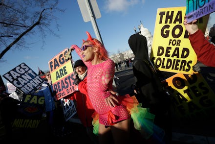 A person in a sheer pink outfit standing in the middle of an anti-gay protest