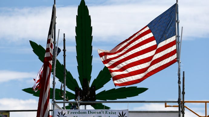 A building in the streets of Denver, and American flag and a large marijuana leaf statue