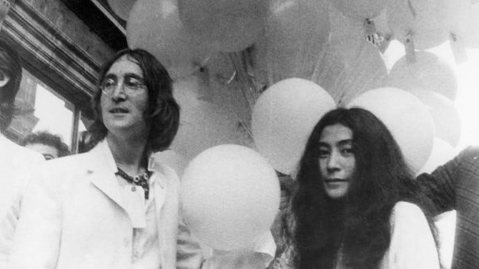 John Lennon and Yoko Ono posing and holding dozens of balloons