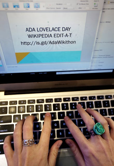 A woman using a laptop and writing a presentation for ada lovelace day