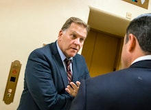 Rep. Mike Rogers speaking to a man next to an elevator
