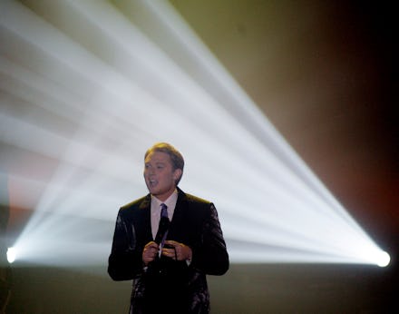 Clay Aiken, who is running for Congress, speaking in front of two stage lights