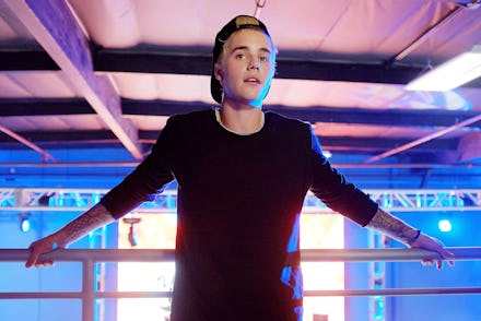 Justin Bieber leaning on a boxing fence