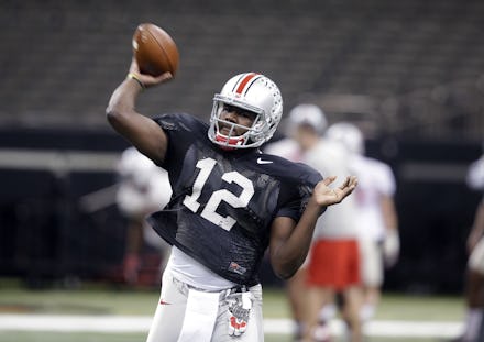  Ohio State University quarterback Cardale Jones holding a football on the pitch