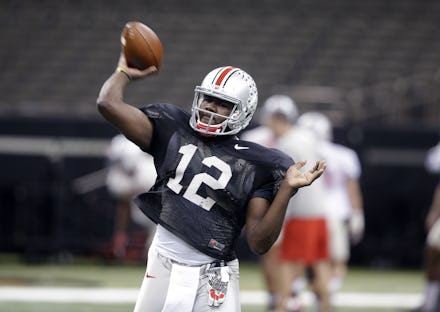 Ohio State University quarterback Cardale Jones holding a football on the pitch