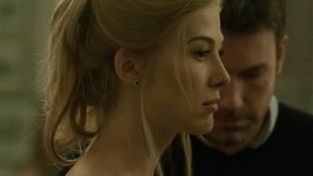 Rosamund Pike looking forward with Ben Affleck in the back looking down in Gone Girl