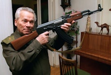 A man in a military uniform holding an ak-47