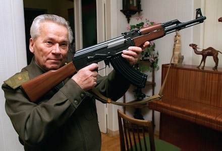 A man in a military uniform holding an ak-47