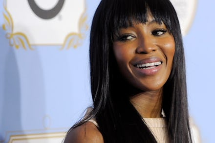 Naomi Campbell with straight long black hair slightly smiling
