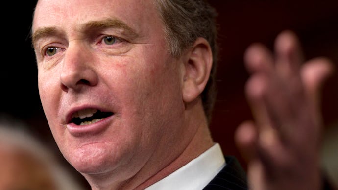 A close-up portrait of Chris Van Hollen speaking with a raised arm