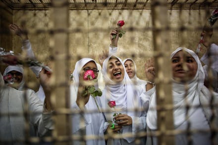 Woman belonging to the Muslim Sisterhood wearing white and holding red roses in egypt