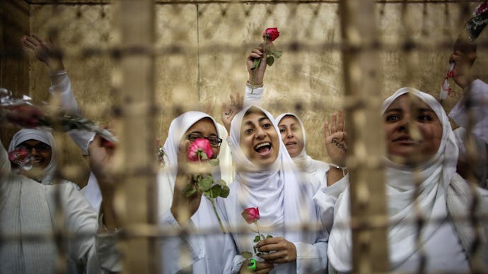 Woman belonging to the Muslim Sisterhood wearing white and holding red roses in egypt