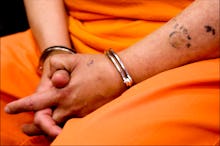 A prisoner sitting in an orange uniform