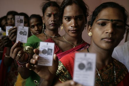 Transgender women holding up their I.Ds, with "other" written as their gender on it.