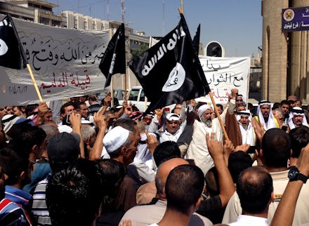 A group of people holding up jihadist flags and signs