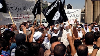 A group of people holding up jihadist flags and signs