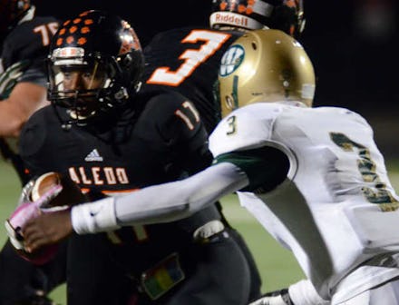 Two high school students playing football for their teams