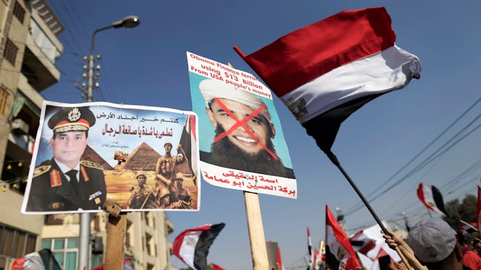 A group of people holding posters with the image of Barack Obama during protests in Egypt