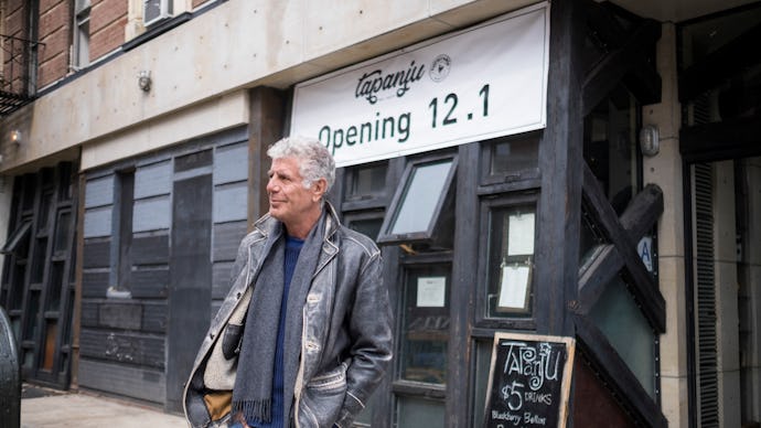 Anthony Bourdain walking on the streets of new york in front of a newly opening restaurant