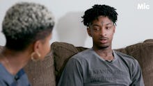 Rapper 21 savage sitting on the couch talking to a woman