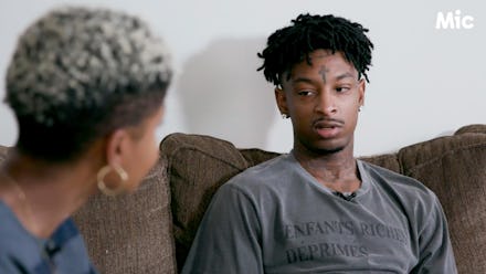 Rapper 21 savage sitting on the couch talking to a woman