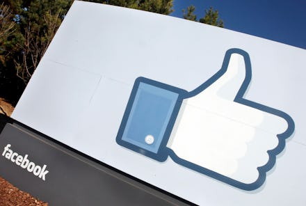 the facebook logo beneath a large sign with the like button on it